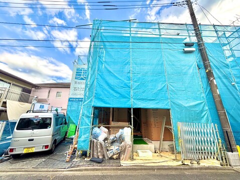 建築中の住宅外観、前に車と自転車があります