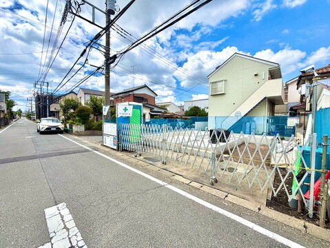 道路沿いの更地で、周辺に住宅や電柱が見えます