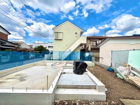 新築建築予定の基礎部分と周辺住宅の様子