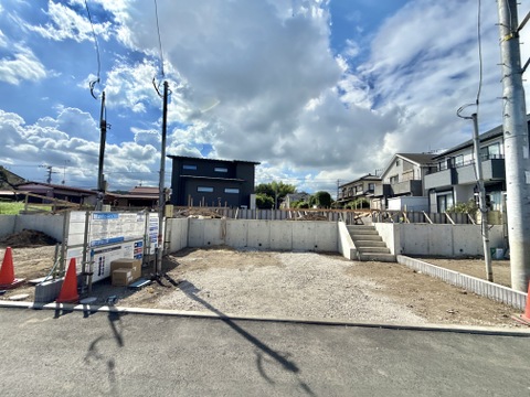 建築予定の更地、周辺に住宅が立ち並ぶ立地