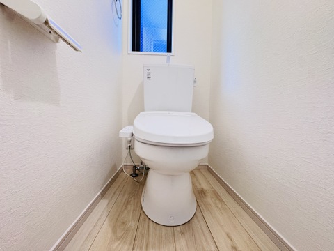 シンプルなトイレルーム、白壁と木目調床