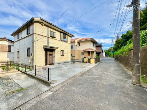 緩やかな坂道沿いに建つ一戸建て住宅の外観です