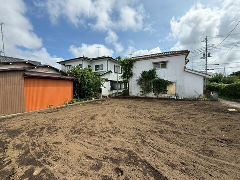住宅地内の更地、隣接する建物が見える