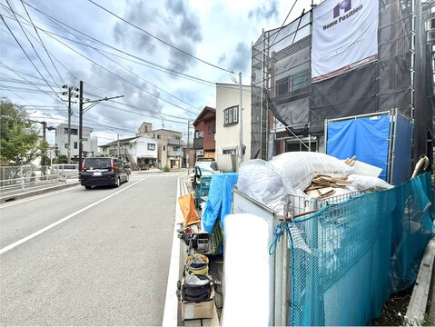 建設中の建物と交通量のある道路の周辺環境