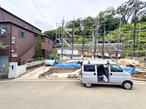 住宅の建設現場と車がある駐車スペースの外観