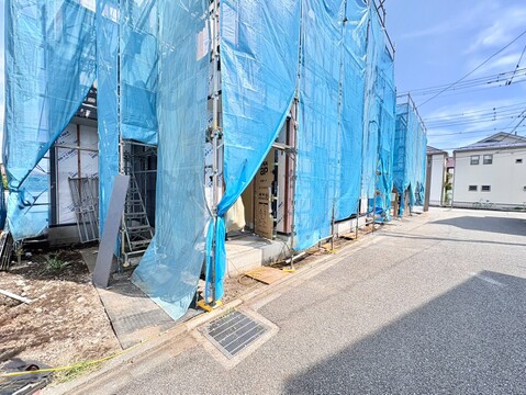 建設中の住宅の外観、整備された道路沿いに位置する