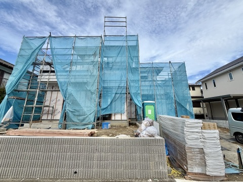 建築中の戸建て住宅外壁工事用の足場と養生シートがある