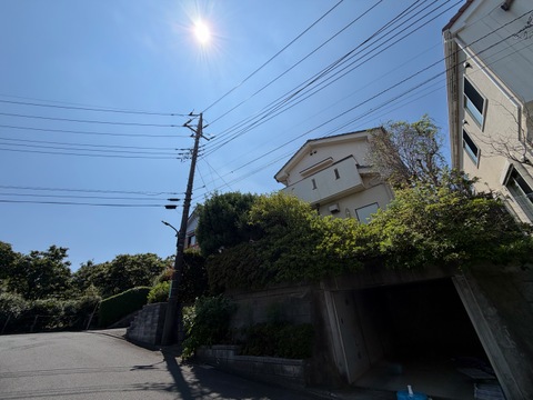 丘の上に建つ住宅と青空が見える外観写真です