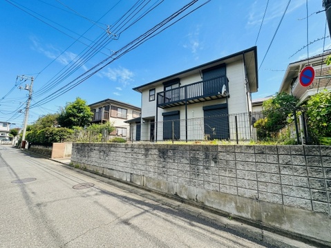 住宅街にある塀と二階建ての戸建て住宅