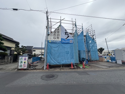 道路沿いに建設中の建物と周辺の街並み