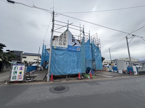 道路沿いの建築中建物青い仮囲いで覆われている