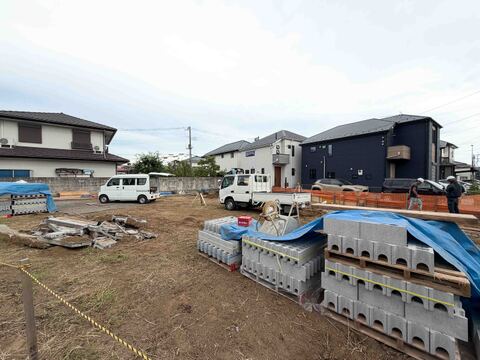 建築中の土地と周囲の住宅が見える風景です