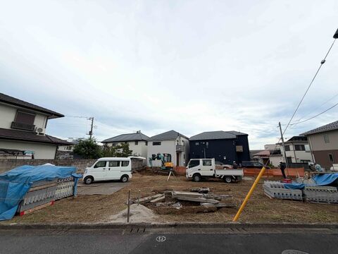 住宅街の建築中の土地と周辺の住宅外観です