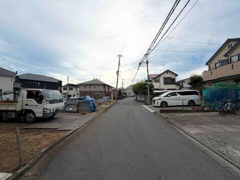住宅街の舗装された道路と周辺の家々の様子です