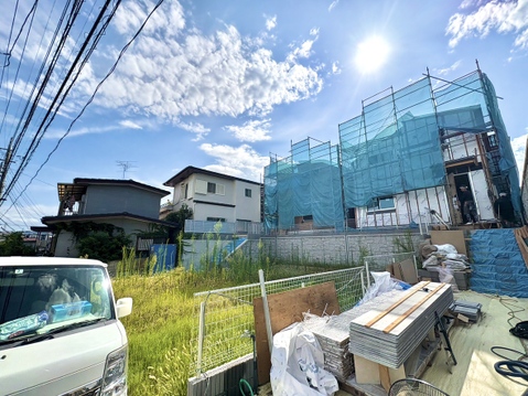 建築中の建物と周辺の住宅が見える敷地