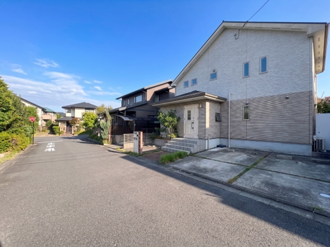 静かな住宅街の二階建て住宅と広い駐車スペース