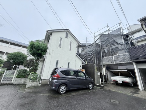 戸建て住宅の外観と駐車スペース、周囲に高低差あり