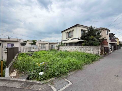 住宅街の角地にある敷地が草で覆われています