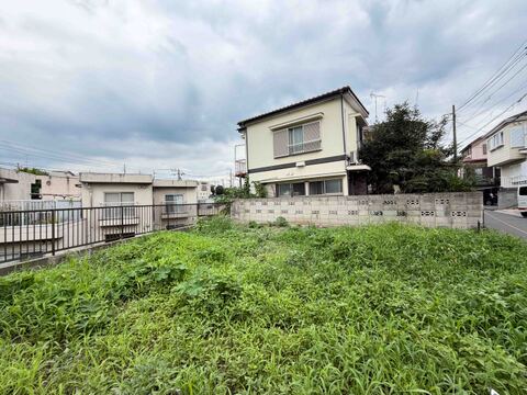 広い芝生の庭と周囲の住宅が見える敷地の様子