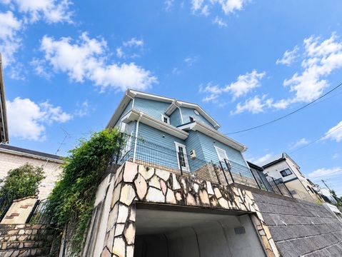 青空の下に見える戸建て住宅の外観
