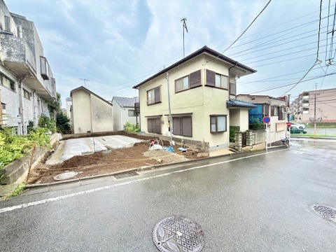 2階建て住宅と隣接する空き地、道路に面した外観