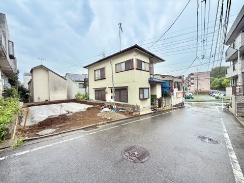 角地に立つ2階建ての住宅と隣接する空き地の様子です