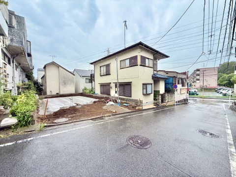 住宅街の一角にある2階建ての住宅と駐車スペースです