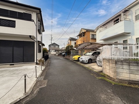 住宅街の静かな道路と駐車スペースが見える外観