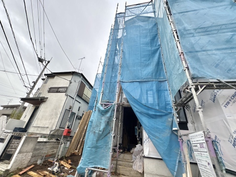 建築中の住宅外観、青い養生シートで覆われています
