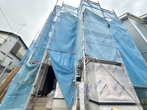 建設中でブルーシートに覆われた住宅の外観