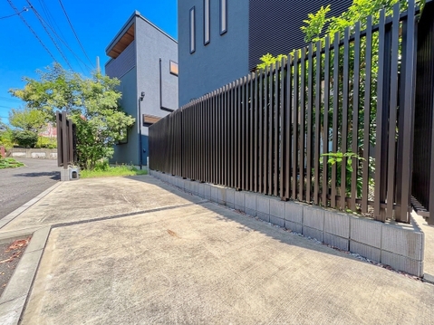 住宅街の歩道とフェンスが整備された外観の一部