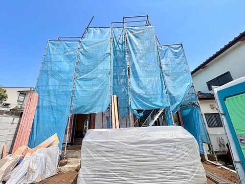 青い養生シートで覆われた建築中の建物