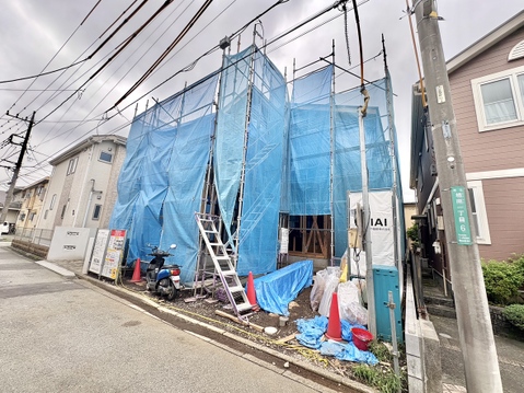 青い養生シートで覆われた建築中の建物