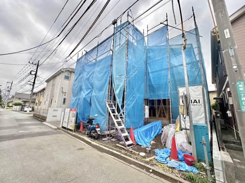 青い養生シートで覆われた建物の外観