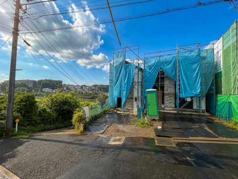 青空の下にある物件外観と前面道路