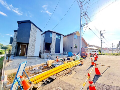 建築中の建物と資材、周囲の道路が見える現地風景