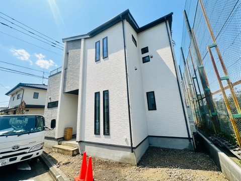 白い外壁の2階建て住宅前面に駐車スペースあり
