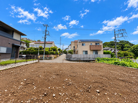 整地された広い土地周囲に住宅や植栽が見える