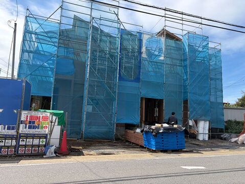 青い養生シートで覆われた建物の外観