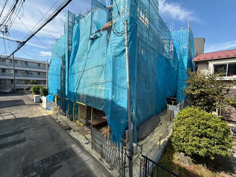 青い養生シートで覆われた建物の外観