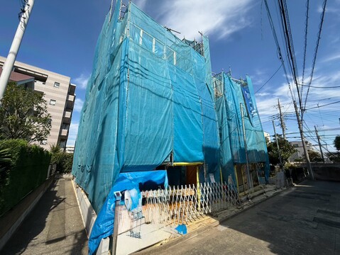 青い養生ネットで覆われた建築中の建物