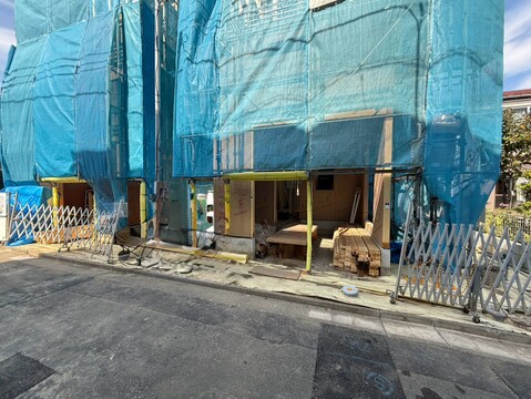 青い養生シートで覆われた建物の外観