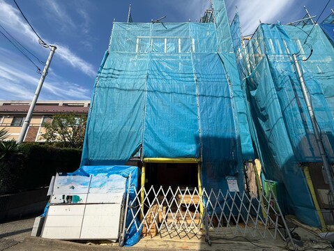青いシートで覆われた建築中の建物外観