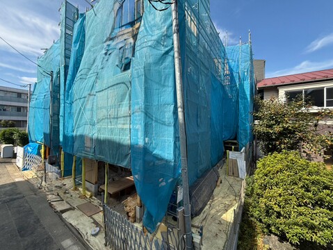 青い養生シートで覆われた建物の外観