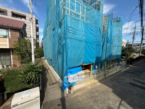 青い養生シートで覆われた建物の外観
