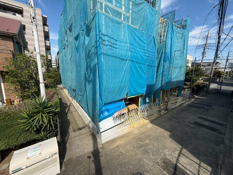 青い養生シートで覆われた建物外観