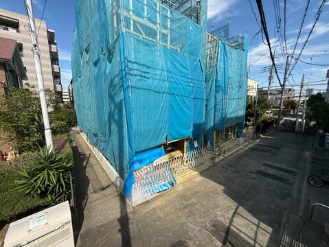 青いシートで覆われた建物と前面道路