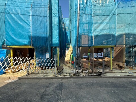 青いシートで覆われた建物と前面道路