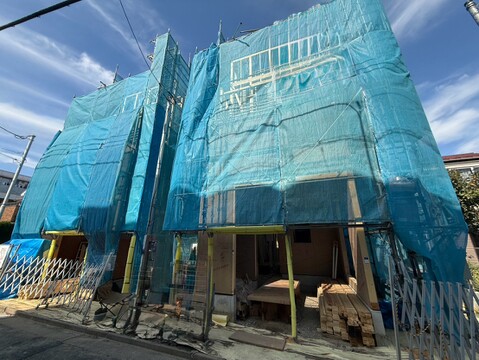 青いメッシュで覆われた建築中の建物外観