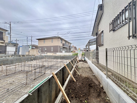 建物沿いの細い通路と周辺の住宅街